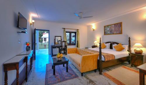 a large bedroom with a bed and a couch at Tiger Den Resort in Khilchipur