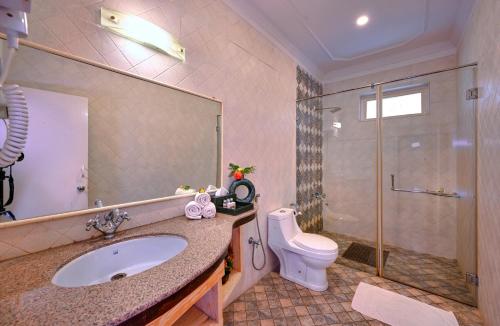 a bathroom with a sink and a toilet and a shower at Tiger Den Resort in Khilchipur