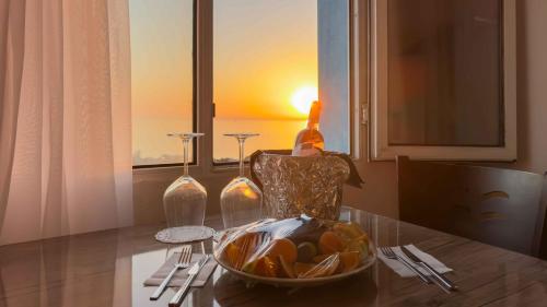 a table with a bottle of wine and a bowl of fruit at La Bella Suit Otel in Kusadası