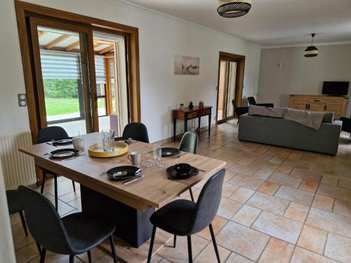 un salon avec une table et des chaises en bois dans l'établissement Longère 5 chambres,proche gare tgv haute picardie, à Dompierre-Becquincourt