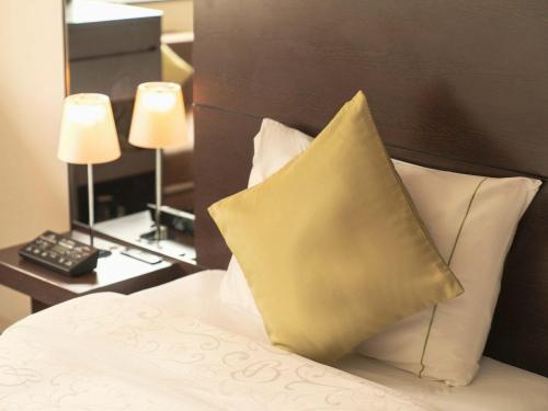 a bedroom with a bed with a pillow on it at Hotel Brighton City Osaka Kitahama in Osaka