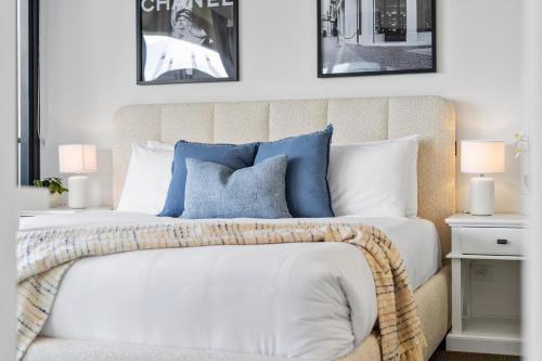 a bedroom with a bed with blue and white pillows at Oracle Resort Broadbeach - gclr in Gold Coast