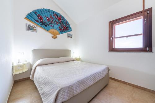 a white bedroom with a bed and a window at Casa Maladroxia in Maladroxia