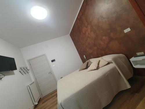 Hotel Ristorante Supersonik في Acri: غرفة نوم صغيرة بها سرير وتلفزيون
