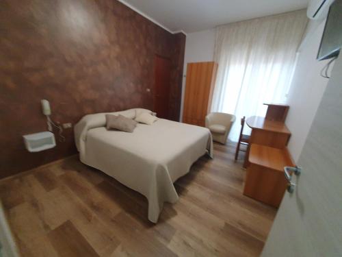 Hotel Ristorante Supersonik في Acri: غرفة نوم بسرير وطاولة وكرسي