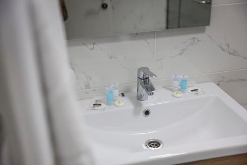 a bathroom sink with a faucet and a mirror at GardenVille Batumi in Batumi