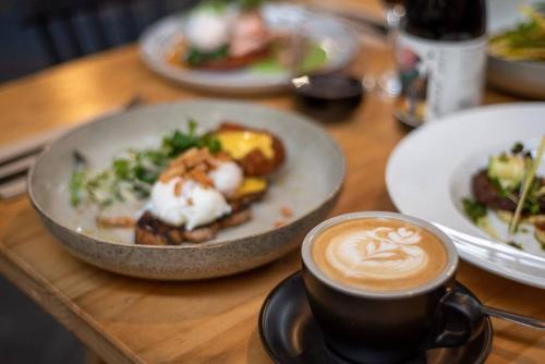 a table with plates of food and a cup of coffee at Badger Creek Hideaway in Badger Creek