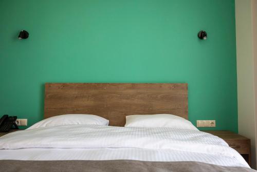 a bedroom with a bed with a blue wall at GardenVille Batumi in Batumi