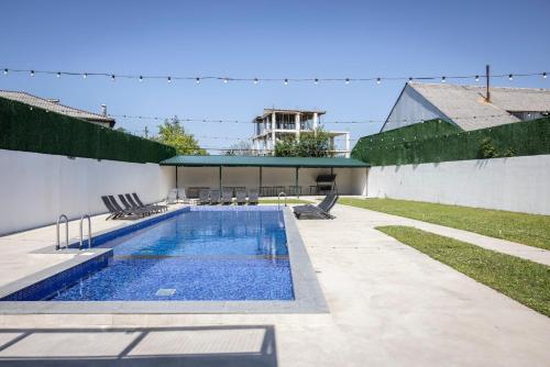 a swimming pool with chairs and a building at GardenVille Batumi in Batumi