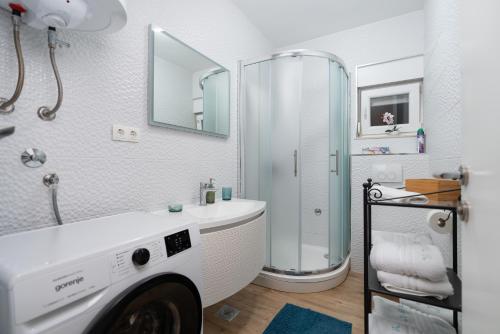 a white bathroom with a sink and a shower at Apartments Stella Per Te in Vir