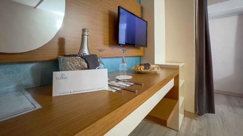a table with a bottle of wine and a bowl of fruit at La Bella Suit Otel in Kusadası