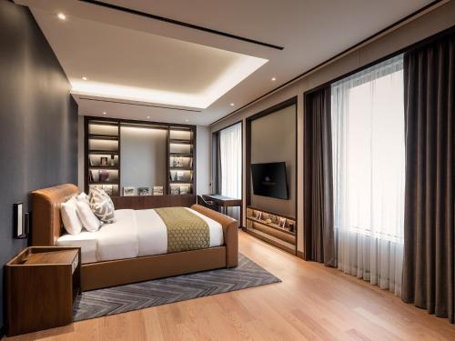 a bedroom with a large bed and a television at Grand Mercure Ambassador Hotel and Residences Seoul Yongsan in Seoul