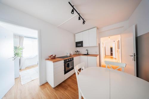 ウィーンにあるCentral City Loftsの白いキャビネットとテーブルのあるキッチン