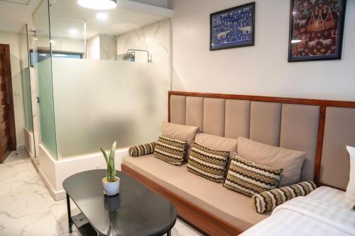 a room with a couch with pillows and a table at Marvelinn Siem Reap in Siem Reap