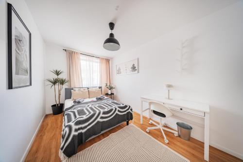 ウィーンにあるCentral City Loftsのベッドと机のある白い寝室