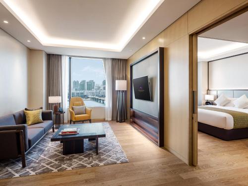a hotel room with a bed and a living room at Grand Mercure Ambassador Hotel and Residences Seoul Yongsan in Seoul