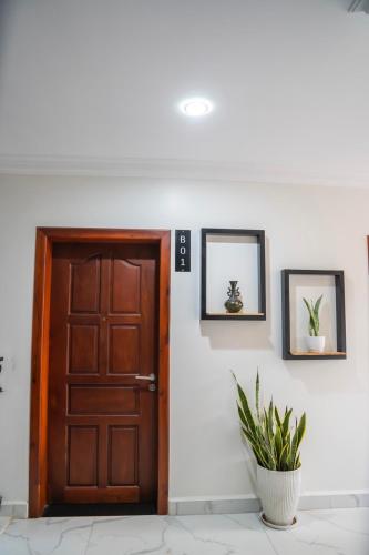 a wooden door in a room with a plant at Marvelinn Siem Reap in Siem Reap
