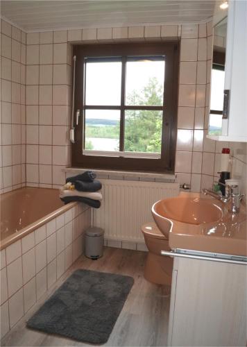 a bathroom with a tub and a toilet and a sink at Haus am Seeufer, Weißenstadt in Weißenstadt