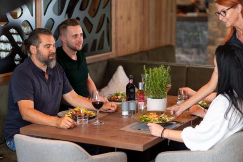 a group of people sitting around a table with food and wine at Bergresort Zugspitze Ehrwald by ALPS RESORTS in Ehrwald