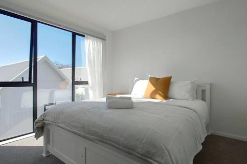 a bedroom with a bed with a laptop on it at Brand-new Modern Princess in One Tree Hill in Auckland
