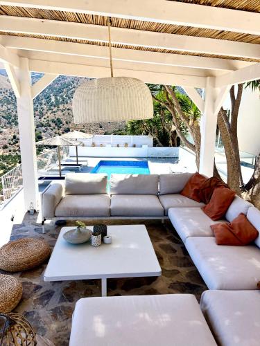 un soggiorno con un divano e un tavolo di Villa Romee with private swimmingpool and panoramic view on Elounda a Eloúnda