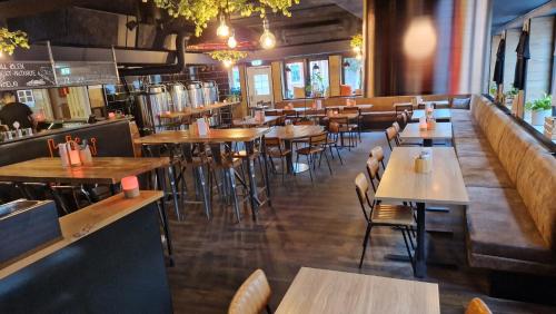 um restaurante com mesas e cadeiras de madeira e um bar em The Brewery Hotel em Karlskrona