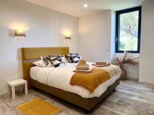 une chambre avec un grand lit avec des oreillers et une fenêtre dans l'établissement Villa du Tallagard, à Salon-de-Provence