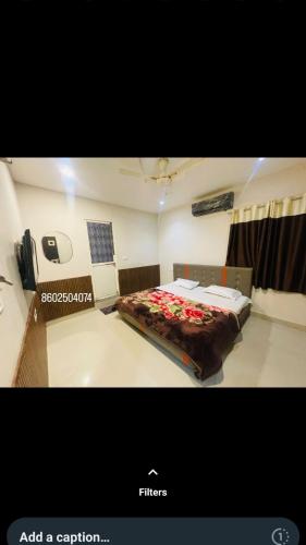 Cette chambre comprend un lit fleuri. dans l'établissement Shree mahakaleshwar homestay, à Ujjain