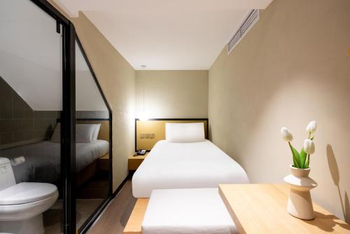 pokój hotelowy z 2 łóżkami i toaletą w obiekcie Tangfu Boutique Hotel Nanluoguxiang Drum Tower Houhai w Pekinie