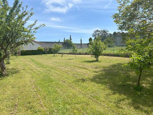 a field with trees and a building in the background at Grupo Gontad Casa Ponteceso Outrabanda 2 in Ponteceso