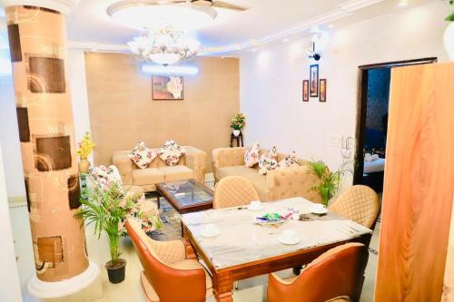 a living room with a table and chairs at Divine India Service Apartment 3 BHK D-198 Saket in New Delhi