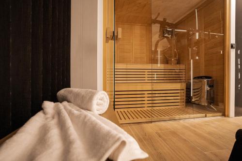 y baño con ducha y toalla. en Indigo Villa with private Pool-Gym-Sauna-BBQ by Hospi, en Heraclión