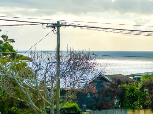 a telephone pole with the ocean in the background at Luxurious Comfort with Bay Views in Frankston South