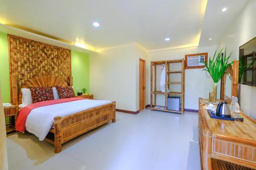 a bedroom with a bed and a television in it at Malapascua Exotic Island Dive Resort in Daanbantayan