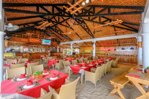 un comedor con mesas y sillas rojas en Malapascua Exotic Island Dive Resort en Daanbantayan