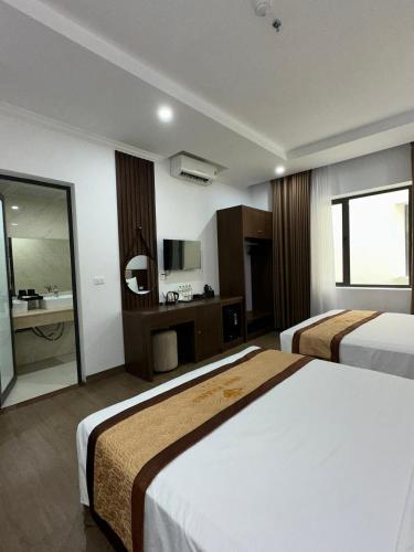 a hotel room with two beds and a bathroom at VĨNH KHANG HẠ LONG HOTEL in Ha Long