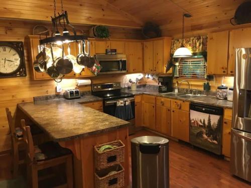 a kitchen with wooden cabinets and a stove top oven at TN State Parks Open! Hikes, Waterfalls, Firepits! in Spencer