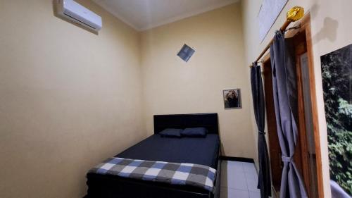 a small bedroom with a bed in a room at Green ijen homestay and tour in Banyuwangi