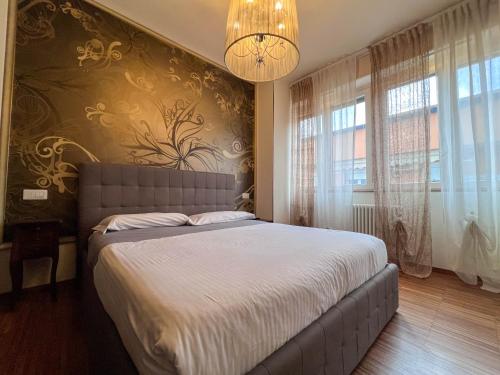 una camera con un grande letto e un lampadario a braccio di Appartamento Crima Luxury a Misano Adriatico