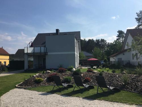 two chairs in a garden in front of a house at Ferienhaus _GlueckSEEligkeit_ in Großkoschen