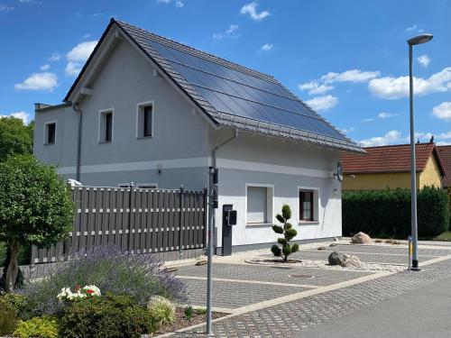 uma casa com painéis solares por cima em Ferienhaus _GlueckSEEligkeit_ em Großkoschen