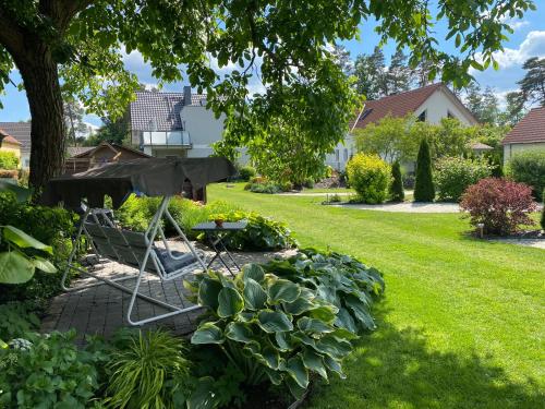a garden with a table and chairs in a yard at Ferienhaus _GlueckSEEligkeit_ in Großkoschen