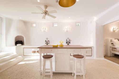 a kitchen with white cabinets and a ceiling fan at Kallos Villas & Suites in Naxos Chora