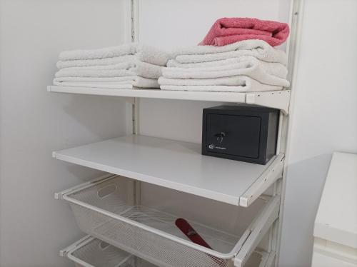einen Schrank mit einem weißen Regal mit Handtüchern in der Unterkunft Estudio Puerto Deportivo Marbella in Marbella