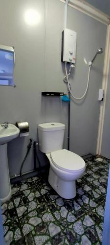 a bathroom with a white toilet and a sink at Guest House Gua Kelam in Kaki Bukit