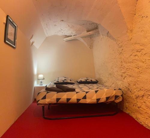 une chambre avec un lit dans un mur de pierre dans l'établissement Les Gîtes de Chauvet, à Gap