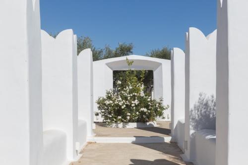 a white gate with a bush of flowers at Kallos Villas & Suites in Naxos Chora