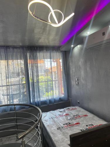 a bedroom with a bed and a ceiling with purple lights at PEYKOXORI 2 LUXURY SUITES BY makhome in Pefkohori