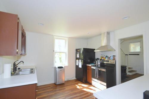 伯克利斯普林斯Broadway Cottage - Town, Hot Tub, Fire Pit, Grill, Wifi, Family Friendly, Pet Friendly的铺有木地板的厨房配有黑色家电