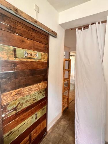 a sliding barn door in a room with a curtain at Vertical House Bali in Uluwatu